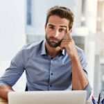 uomo perplesso davanti a un PC lento all'avvio