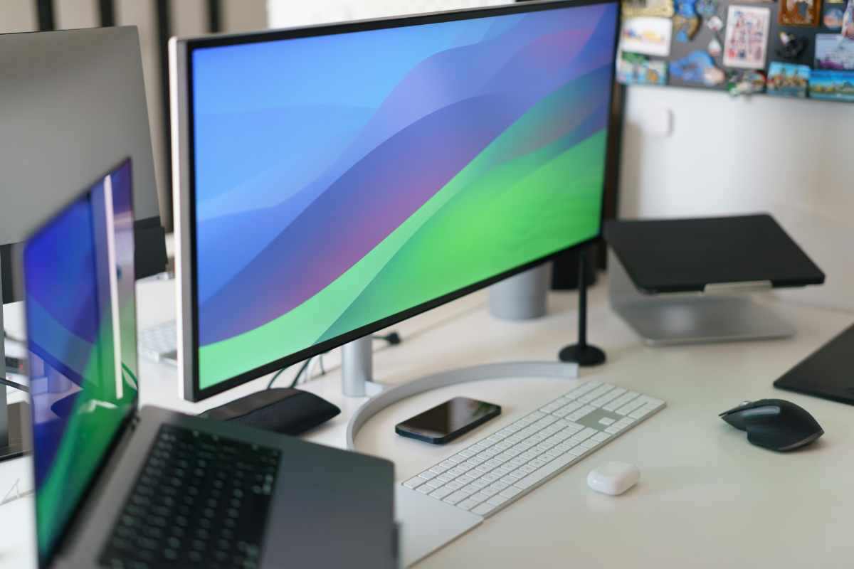 schermo, tastiera, pc desktop e portatile su un tavolo