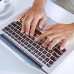 mani sui tasti di un laptop