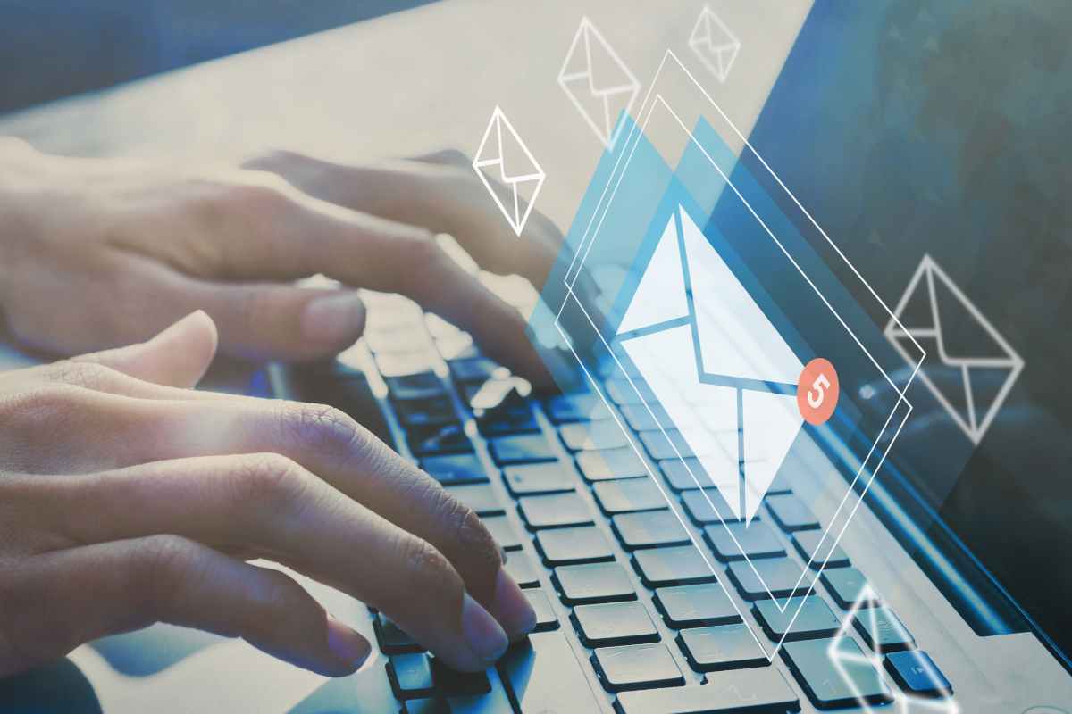 mani sulla tastiera per computer portatile e illustrazione di una mail in arrivo