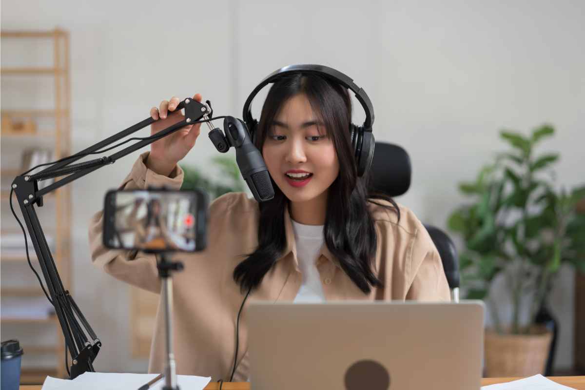 ragazza registra un podcast parlando davanti a un microfono