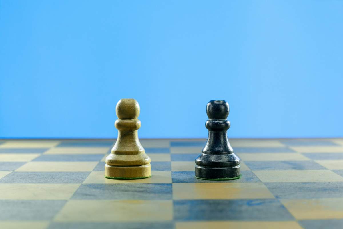 Pedone bianco e nero su una scacchiera