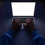 Persona al laptop al buio