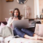 Ragazza che ride con smartphone e laptop