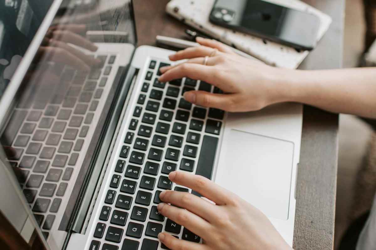 Mani che scrivono sul laptop