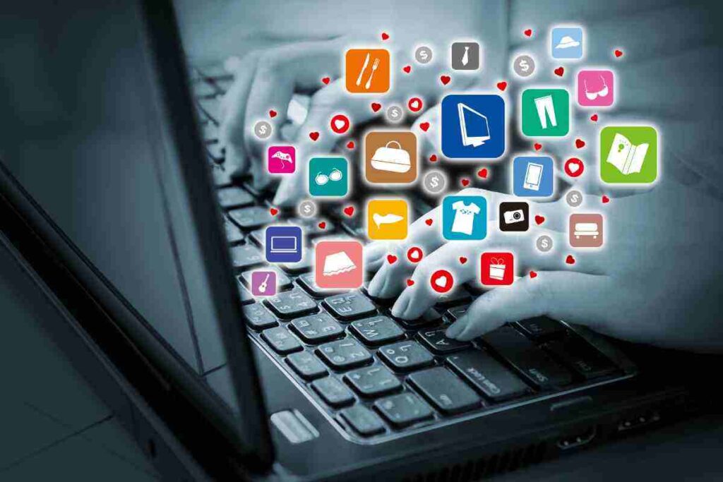 mani che usano un pc con icone varie che escono dallo schermo