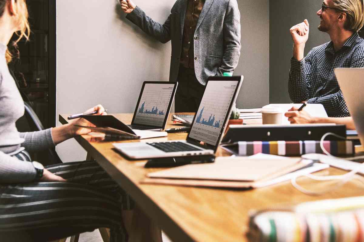 Persone al laptop attorno a un tavolo