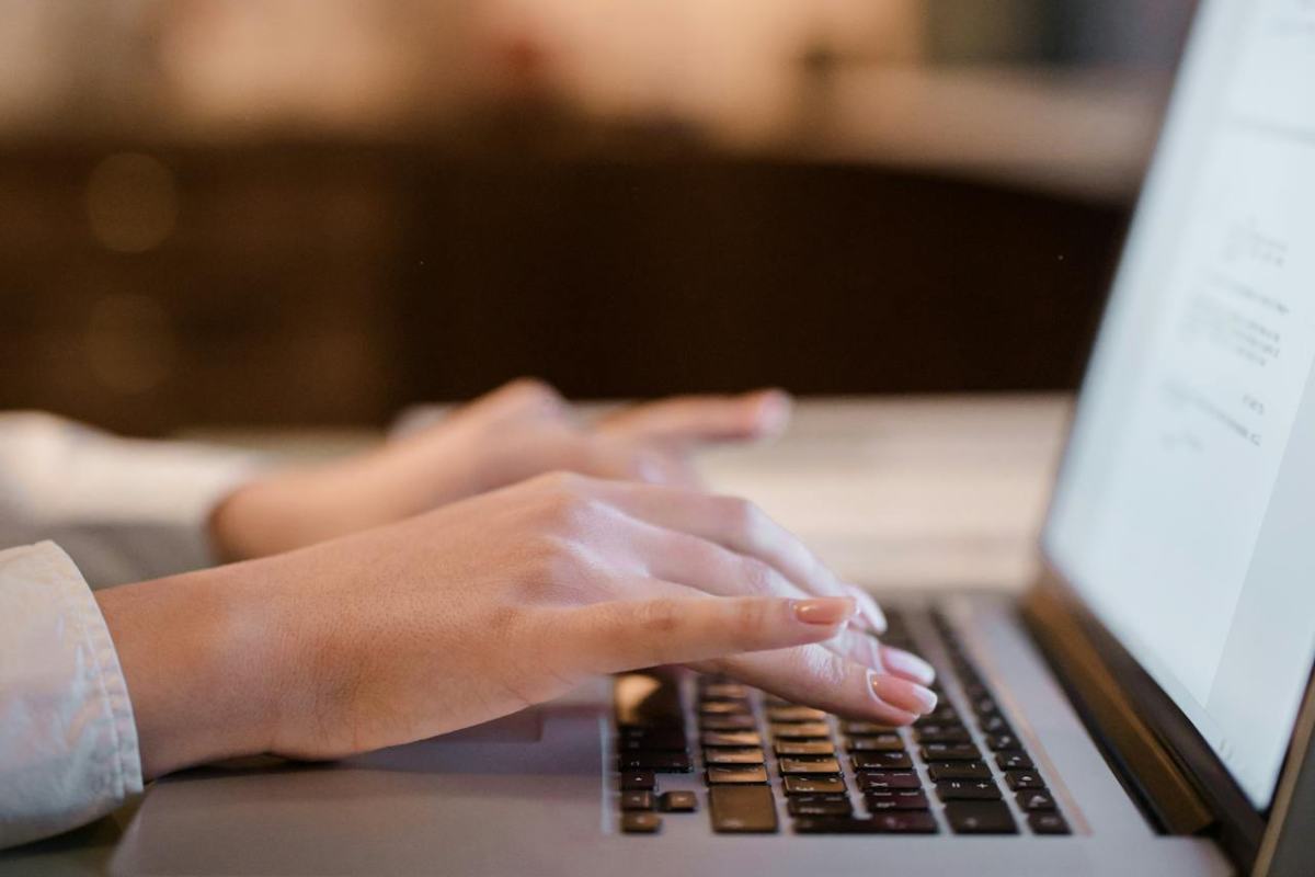 Mani che digitano al laptop