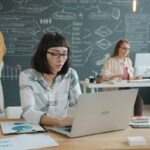 Ragazza al laptop seduta che lavora