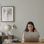 Ragazza al laptop seduta alla scrivania