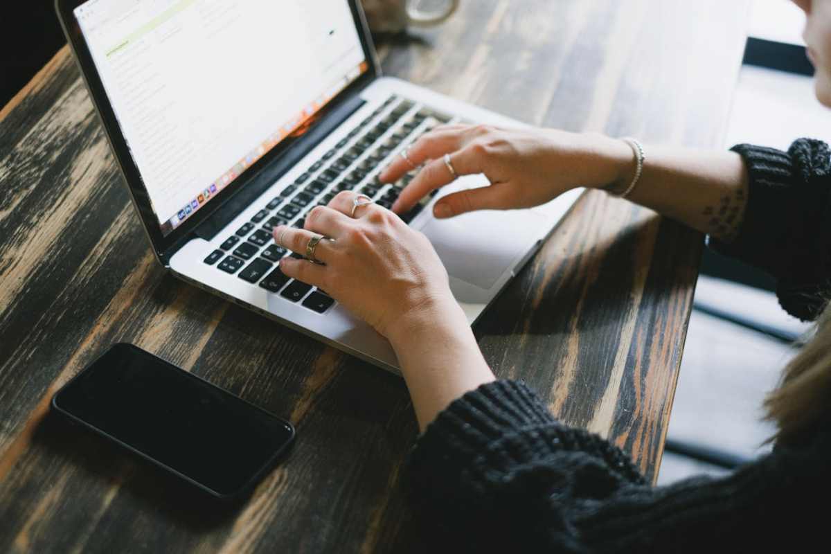 Mani che digitano su laptop